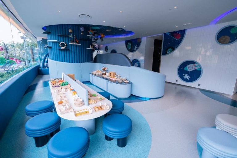 Restaurante temático espacial con mesas y taburetes azules en Grande Centre Point Space Pattaya