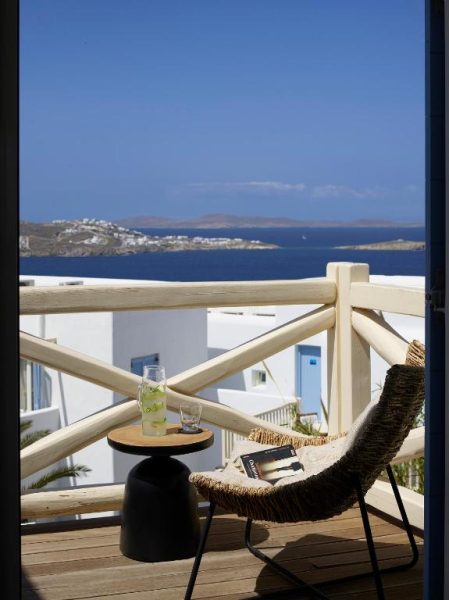 Terraza privada con silla de ratán y vistas al mar Egeo en Vencia Boutique Hotel Mykonos