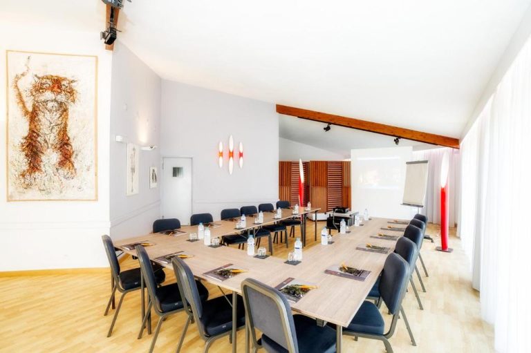 Sala de reuniones en U con proyector y sillas en el Hotel Le Noirlac, ideal para conferencias y eventos