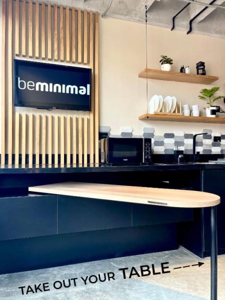 Cocina moderna con mesa extensible plegable y zona de microondas en hotel beminimal parques