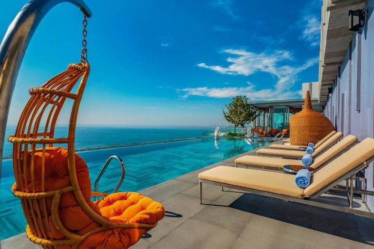 Piscina infinita con vistas al mar y tumbonas en la terraza del Le Sands Oceanfront Danang Hotel