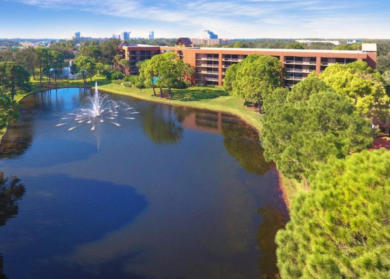 Vista aérea del lago con fuente ornamental y jardines del Rosen Inn Lake Buena Vista en Orlando