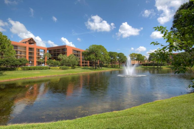 Lago con fuente decorativa y jardines del Rosen Inn Lake Buena Vista en Orlando, Florida