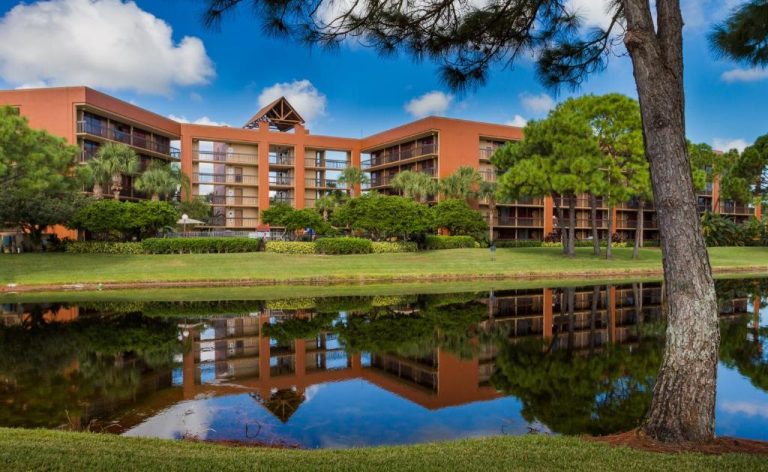 Vista exterior del Rosen Inn Lake Buena Vista con lago artificial y jardines rodeados de pinos