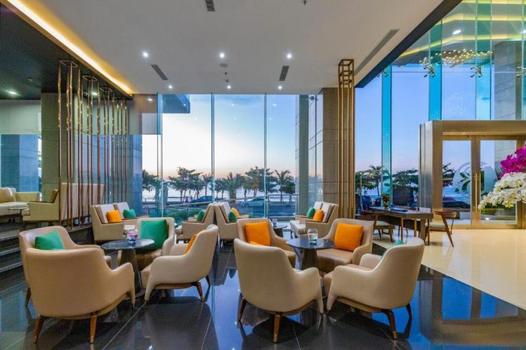 Elegante lobby lounge con sillones y vistas panorámicas al mar del Le Sands Oceanfront Danang Hotel