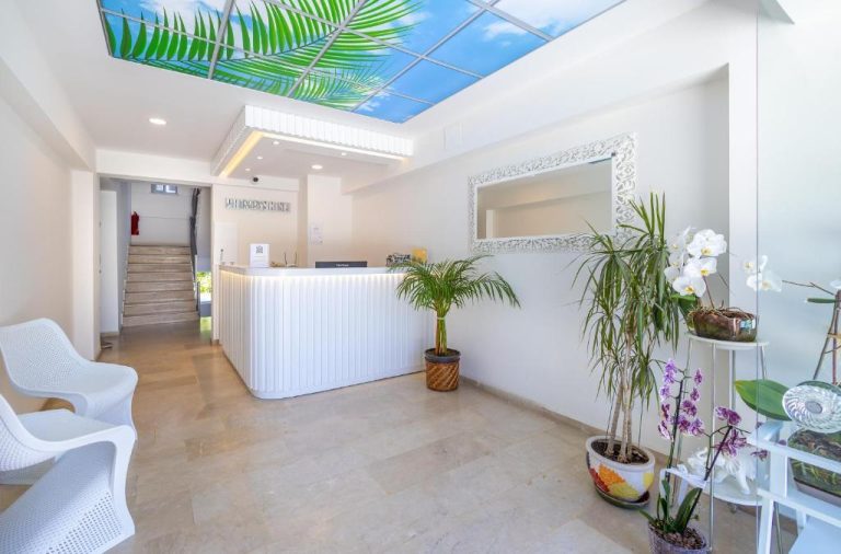 Recepción luminosa con decoración tropical del Princess Kinli Suites Hotel con plantas y techo decorativo