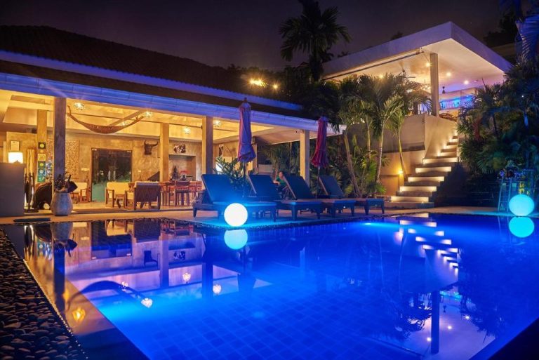 Piscina iluminada de noche con esferas luminosas en el Baan Sawan Samui Resort en Tailandia