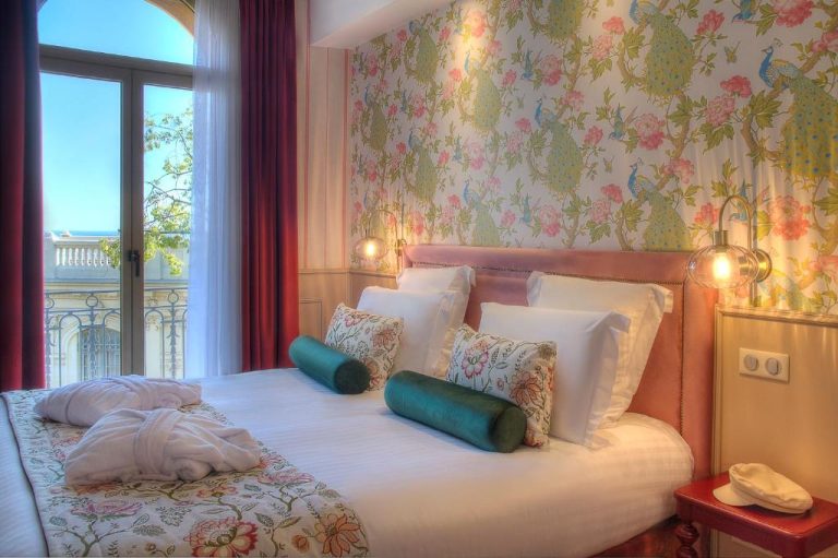 Habitación doble con decoración floral y vistas al balcón en el Hôtel Petit Palais