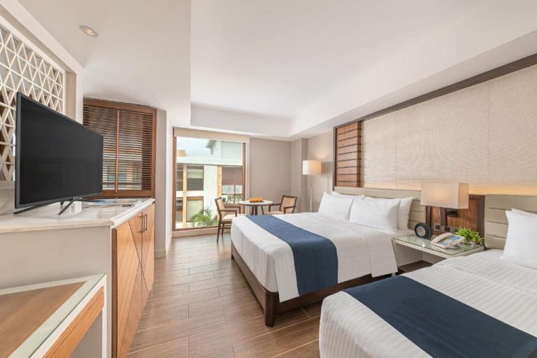 Habitación doble con dos camas y terraza en Henann Crystal Sands Resort, decoración moderna y luminosa