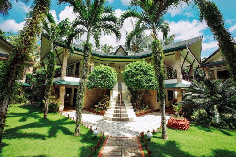 Fachada principal con jardines tropicales y palmeras del Paradise Garden Hotel and Convention Center Boracay
