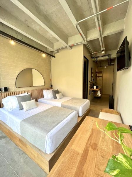 Habitación doble con diseño industrial y dos camas en Hotel Beminimal Parques