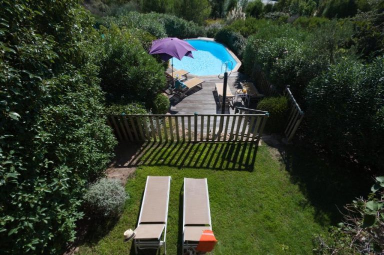 Piscina exterior con terraza de madera y jardín privado en Résidence Marina Di Santa Giulia