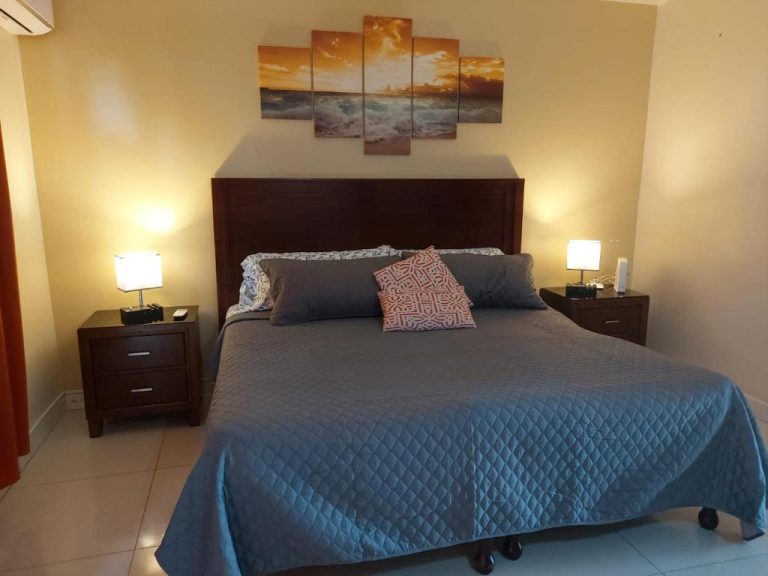 Habitación doble con cama queen y decoración de atardecer en Deluxe SandCastles Condos