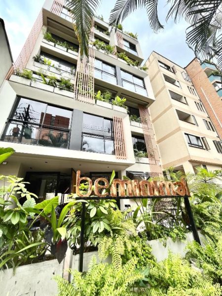 Fachada exterior del hotel Beminimal Parques con terrazas ajardinadas y vegetación tropical en Medellín