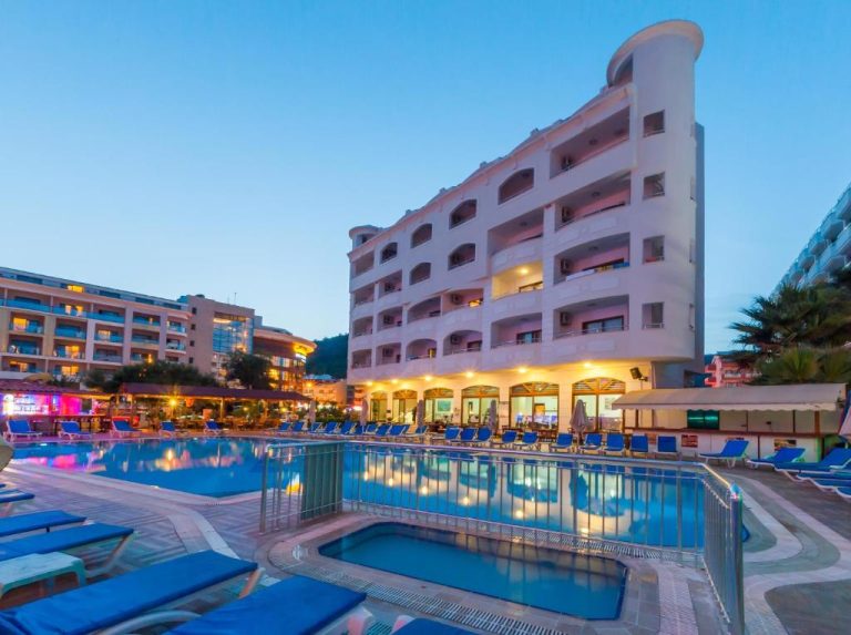 Piscina exterior iluminada al atardecer con tumbonas azules del My Dream Hotel