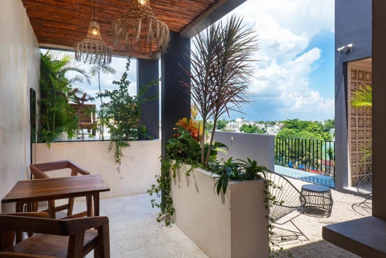 Terraza con plantas tropicales y vista panorámica de la ciudad en UJO Condo Boutique
