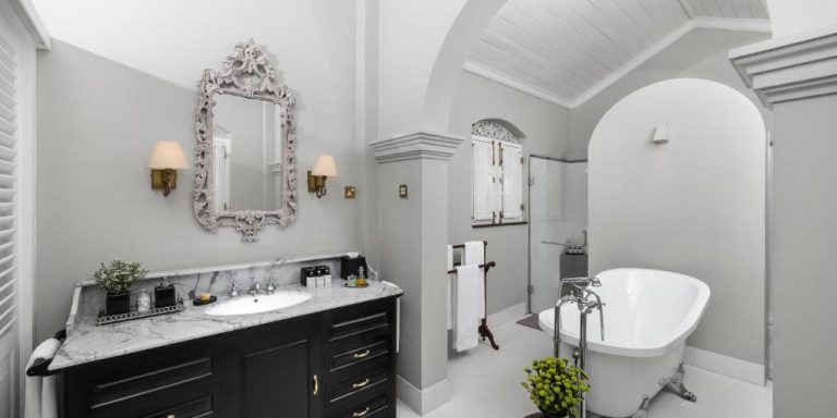 Baño clásico de lujo con bañera exenta y mueble de mármol en el Maniumpathy Hotel