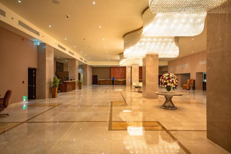 Amplio lobby del Marino Beach Colombo con suelo de mármol, columnas elegantes y gran lámpara de cristal