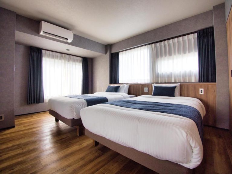 Habitación twin con dos camas dobles, suelo de madera y aire acondicionado en Hotel Ulu Tokyo