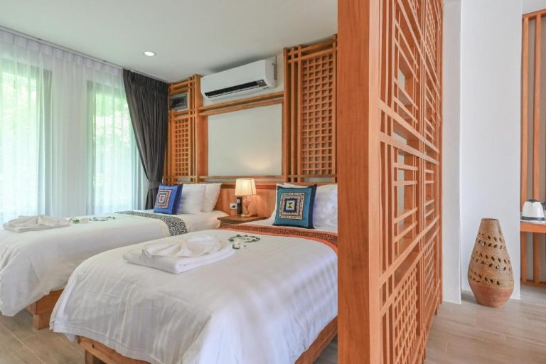 Habitación doble con decoración de madera tallada y ropa de cama blanca en el hotel Cascade Tara