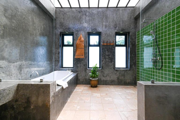 Baño de lujo con bañera empotrada y ducha de azulejos verdes en el hotel Cascade Tara