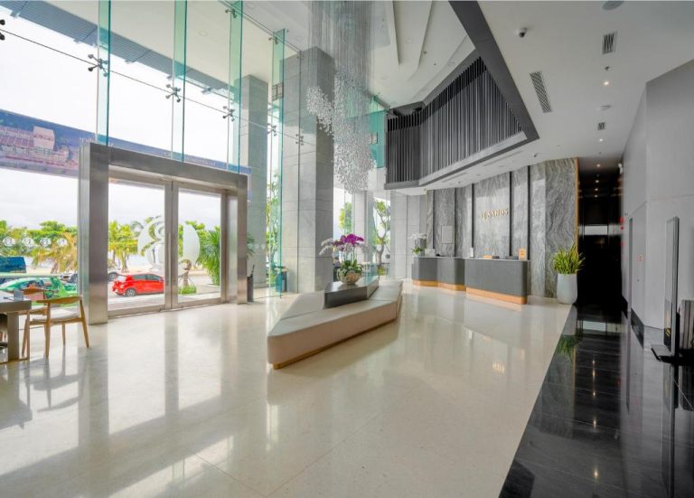 Amplio lobby moderno con recepción elegante y vistas al exterior del Le Sands Oceanfront Danang Hotel