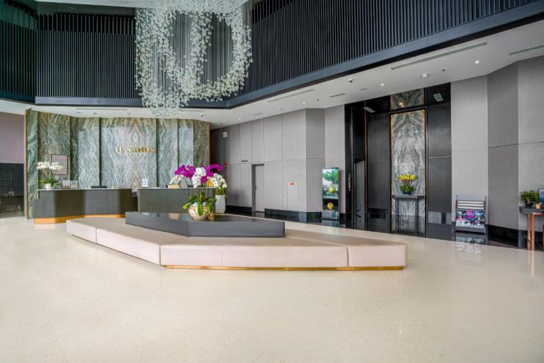 Elegante lobby y recepción del Le Sands Oceanfront Danang Hotel con decoración de mármol y flores