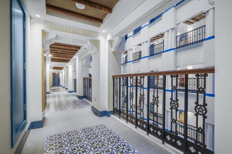 Pasillo interior de estilo árabe con balcones y azulejos decorativos en Central Inn Souq Waqif