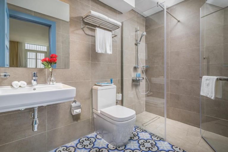 Baño moderno con ducha de mampara y suelo hidráulico en Central Inn Souq Waqif