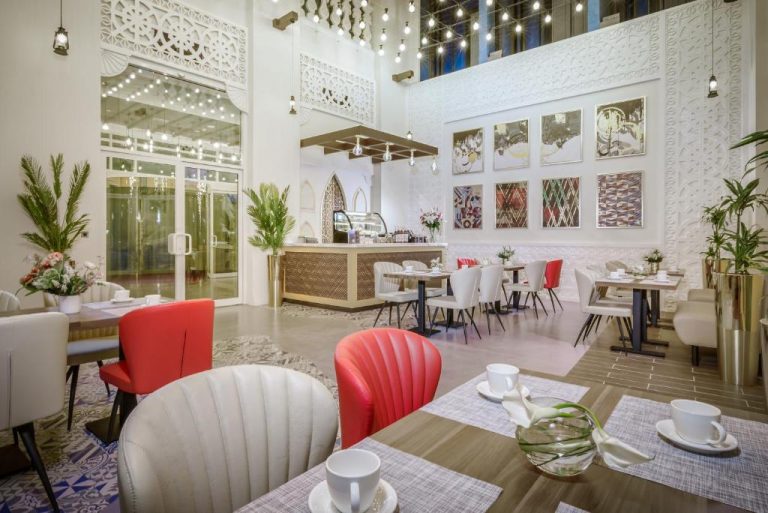 Restaurante interior elegante con sillas rojas y blancas del Central Inn Souq Waqif en Doha