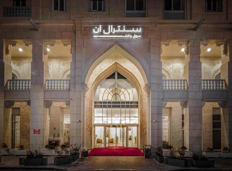 Entrada principal del Central Inn Souq Waqif con arcos de estilo árabe y alfombra roja iluminada