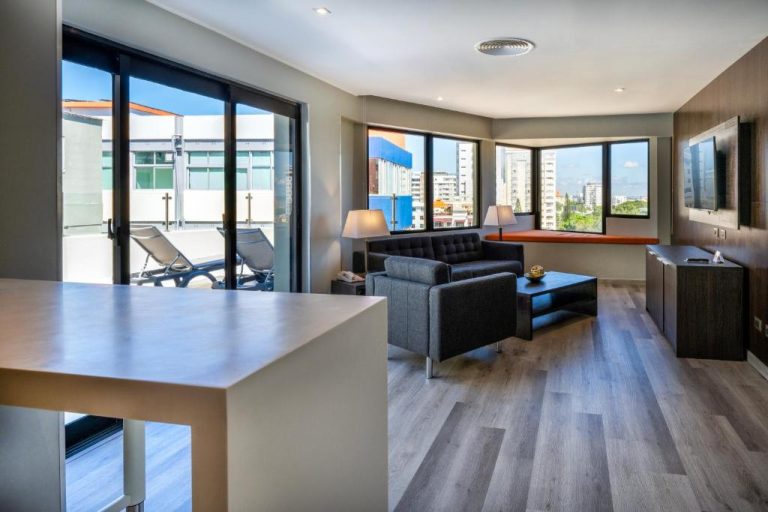 Suite con sala de estar moderna y terraza privada con vistas a la ciudad en W&P Santo Domingo