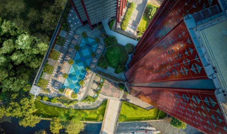 Vista aérea de la piscina exterior y jardines del Chatrium Grand Bangkok junto al río Chao Phraya