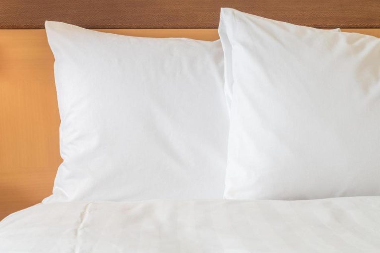 Cama con almohadas blancas y ropa de cama impecable en Holiday Inn Express Starke by IHG