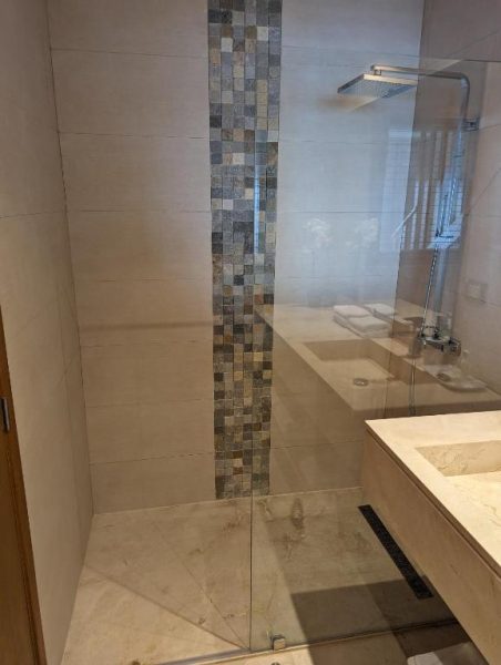 Ducha de mármol con panel de mosaico y lluvia empotrada en Hacienda Samana Bay Hotel