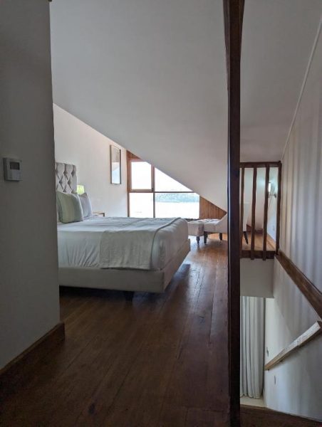 Habitación abuhardillada con cama doble y suelos de madera en Hacienda Samana Bay Hotel