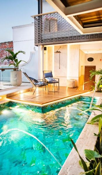 Piscina privada con deck de madera y zona lounge del Hotel Casona del Porvenir con iluminación nocturna