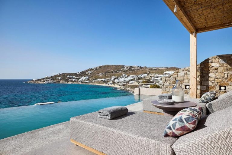 Piscina infinita con vistas al mar turquesa y terraza del Amazon Mykonos Resort and Spa