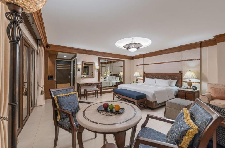 Suite deluxe con cama king size y zona de estar elegante en Henann Regency Resort and Spa