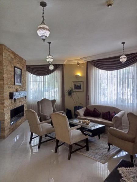 Elegante salón con chimenea, sillones clásicos y lámparas orientales en Mariam Hotel