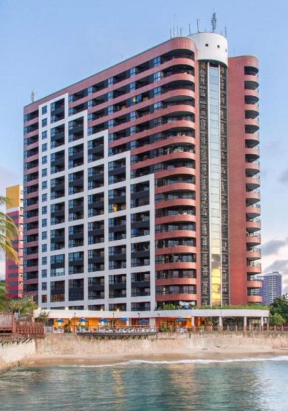 Fachada exterior del Iate Plaza Flat 613 frente al mar con balcones y área de restaurante en la playa