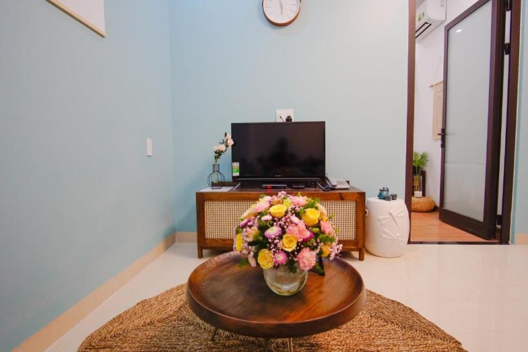 Salón con televisión y decoración floral colorida en Phuong Tran Apartment and Hotel