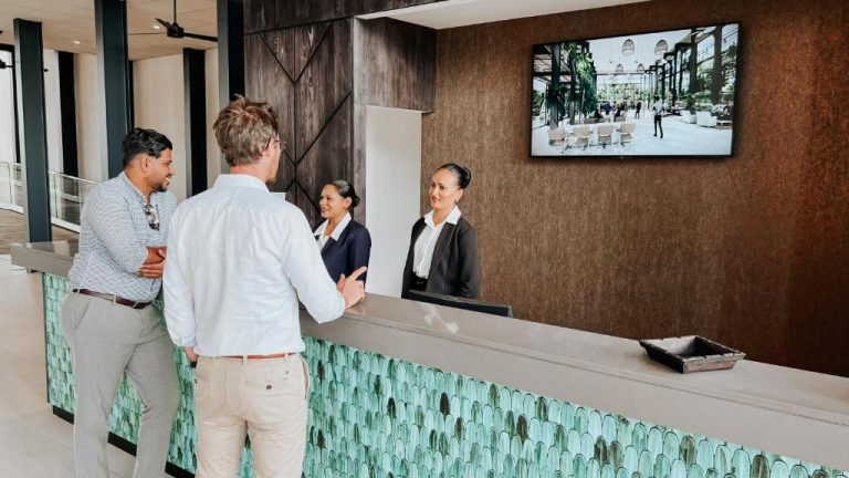 Recepción moderna del Royal Green Wellness Resort con personal atendiendo a huéspedes en el lobby