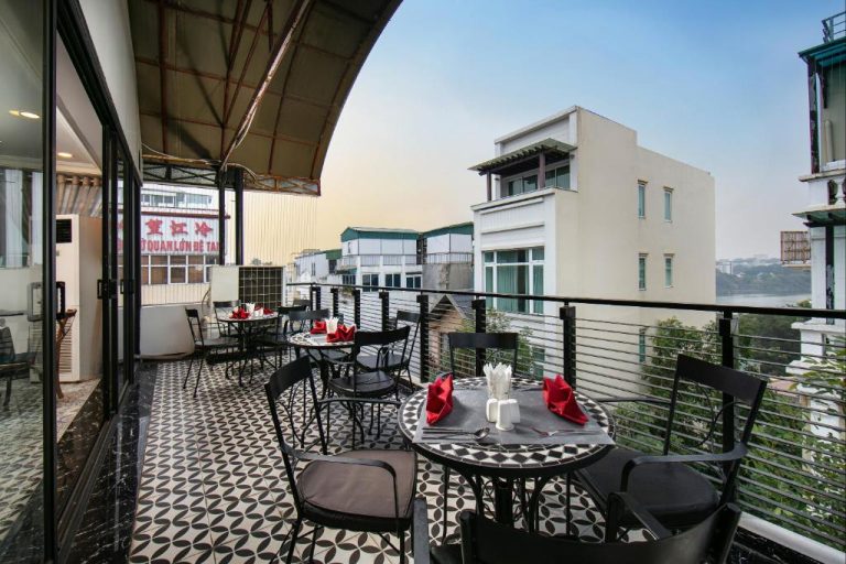 Terraza restaurante con mesas y vistas a la ciudad en San Boutique Hotel & Travel de Vietnam