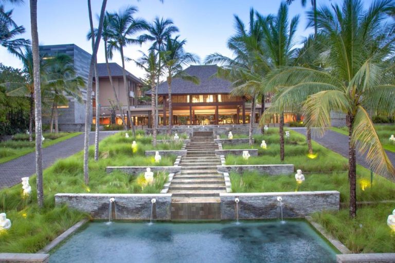 Fuente ornamental y jardines tropicales con palmeras en Courtyard by Marriott Bali Nusa Dua Resort