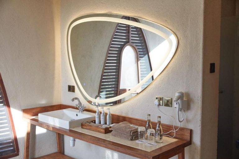 Baño de lujo con espejo LED retroiluminado y lavabo de madera en Surana Buffalo Springs