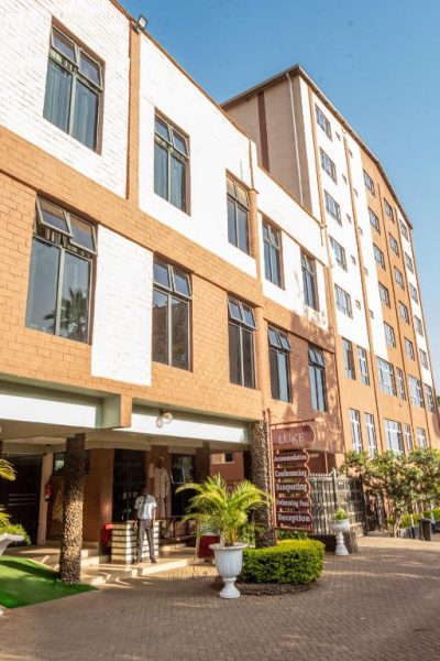 Fachada exterior del The Luke Hotel Roasters con entrada principal y jardines tropicales