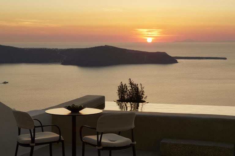 Terraza con piscina infinita y vista al mar al atardecer en Atoles Retreat Santorini