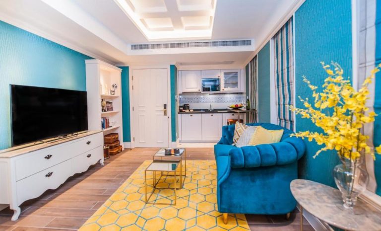 Salón con sofá azul y cocina integrada en el Hotel Madera Hollywood con decoración moderna