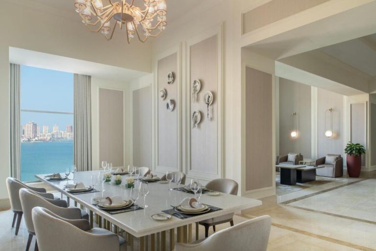 Elegante comedor con mesa para diez comensales y vistas al mar en The St. Regis Doha